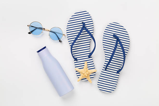 istock Striped blue flip flops with accessories on color background, top view 2217687126