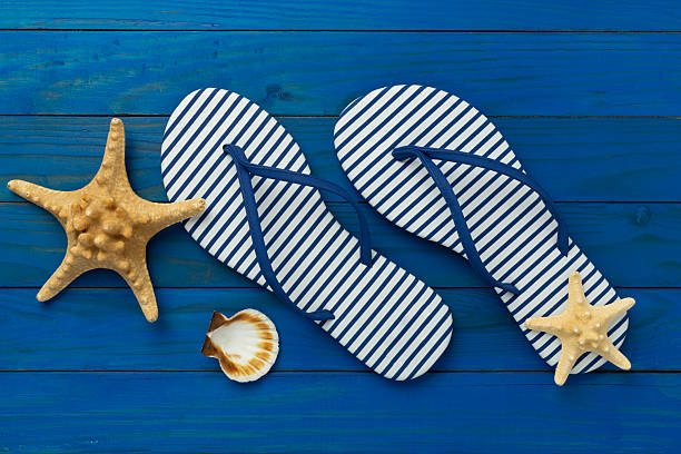 istock Striped blue flip flops on wooden background, top view 2217687141