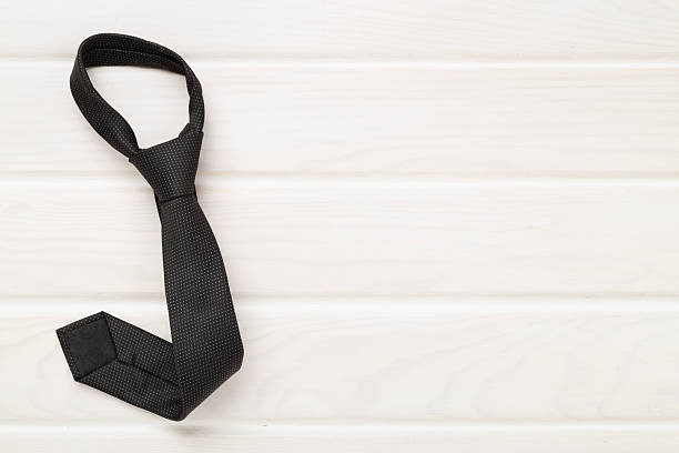 istock Black tie on wooden background, top view 2217689077