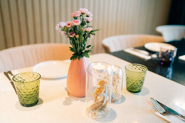 Table setting with decorative vase and candle holders in a modern dining space during daylight
