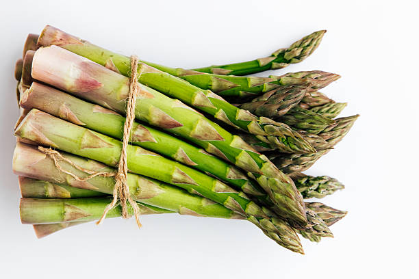 istock Fresh asparagus bundle tied with twine on a plain background ready for cooking 2217693625