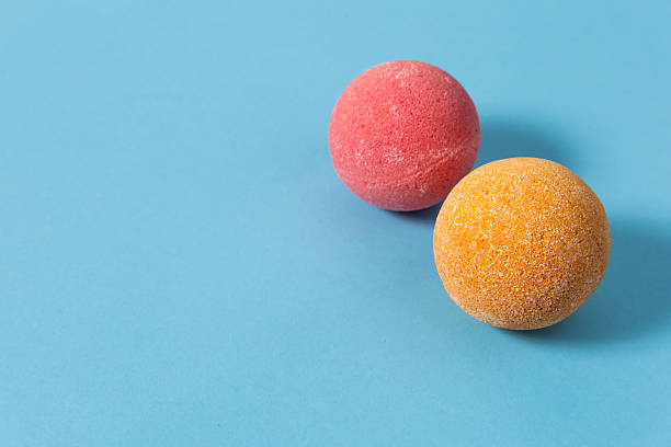 istock Colorful bath bombs resting on a soft blue background during a relaxing spa setting 2217693679
