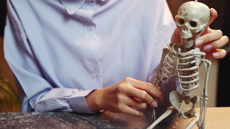 Close-Up of a Person Interacting with a Human Skeleton Model for Educational or Medical Purposes