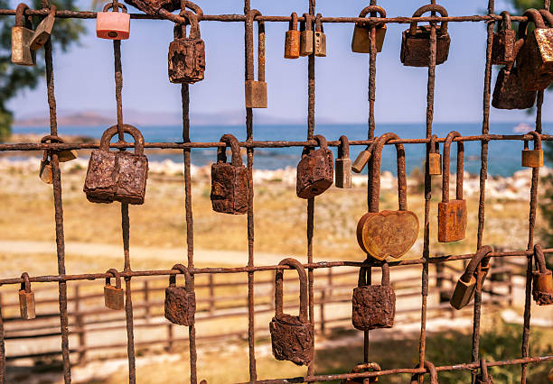 Love lock. Rusty padlocks on metal fence grid, closeup view. Love and commitment concept