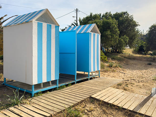 Beach cabins on sand. Small huts with blue stripes, sandy beach in Chania Crete island, Greece