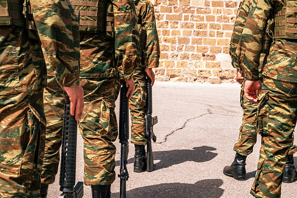 istock Soldiers wearing camouflage pattern uniforms standing, carrying rifles 2217696446