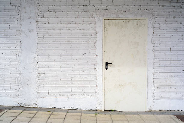 istock White door in white brick wall alley 2217697702