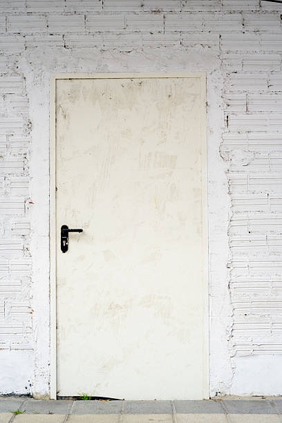 White door in white brick wall alley