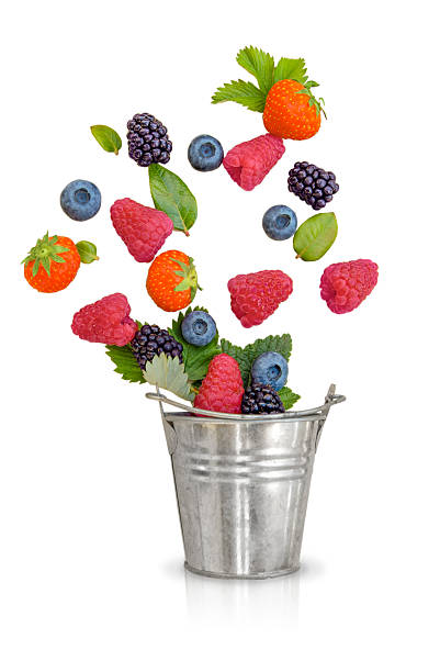 An assortment of fresh mixed berries including strawberries, raspberries, blackberries, and blueberries, appearing to fall into a shiny metal bucket. The image is isolated on a clean white background, symbolizing freshness, health, and summer produce. Perfect for use in food concepts, healthy living, nutrition, or organic marketing materials.