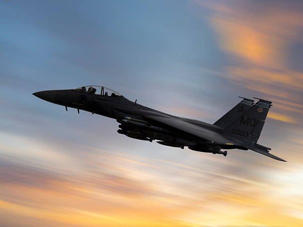 istock F-15 Fighter jet in flight over the clouds at sunset. 2217701425