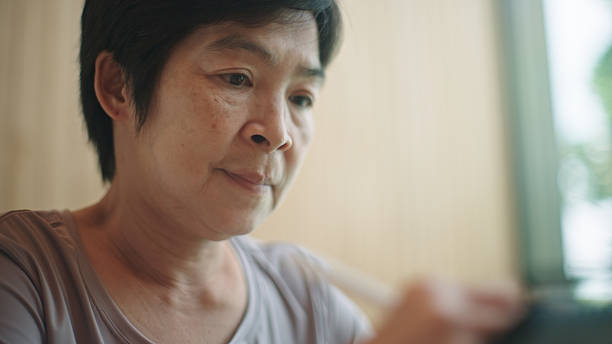 istock Mature woman writing on digital tablet. 2217702976