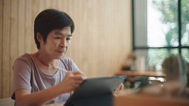 istock Mature woman writing on digital tablet. 2217702978
