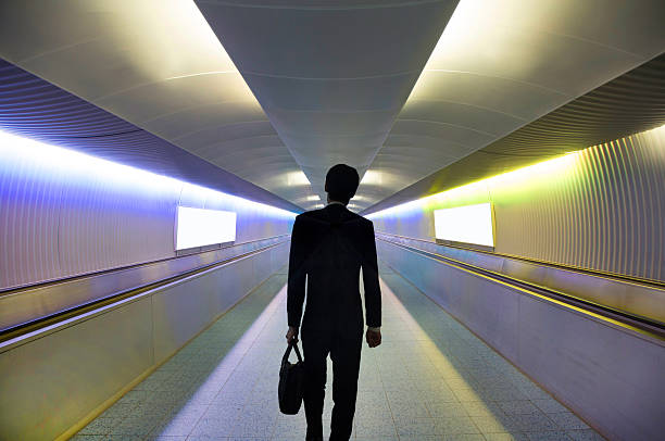 istock Businessman walking in connecting tunnel. 2217705437