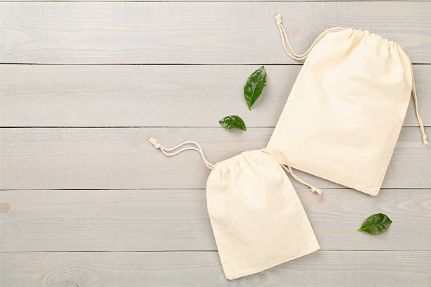 istock Small eco sacks on wooden background, top view 2217709423