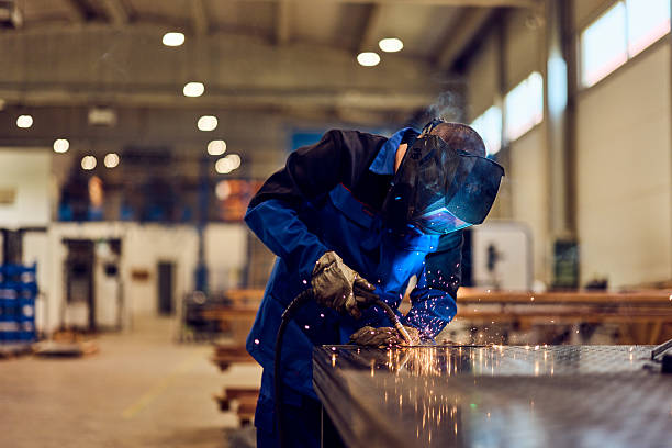 istock Worker Welding Metal Pieces in an Industrial Workshop with Protecting Gear 2217709479