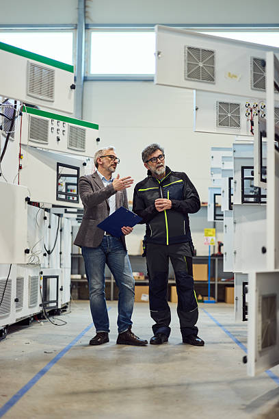 istock Two Engineers Discussing Equipment in a Modern Industrial Workshop 2217709507