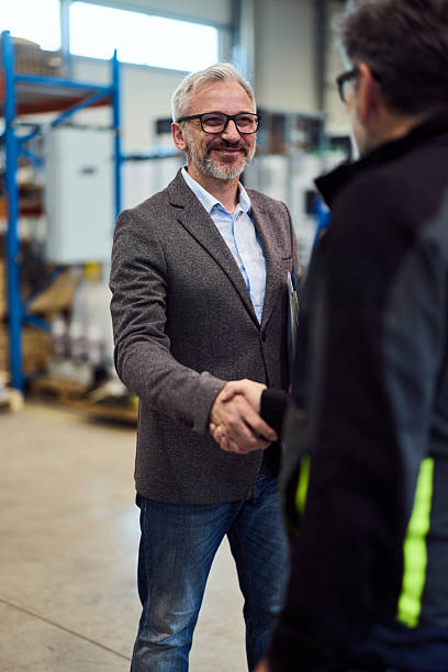 istock Businessmen Shaking Hands in a Warehouse Environment with Friendly Collaboration Spirit 2217709514