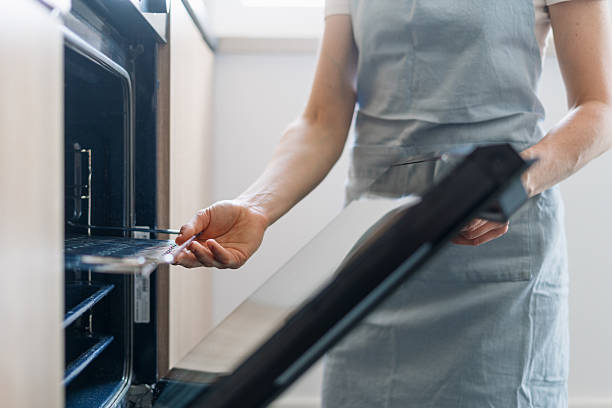 istock Modern electric oven in a well-designed kitchen with a person using it 2217713836