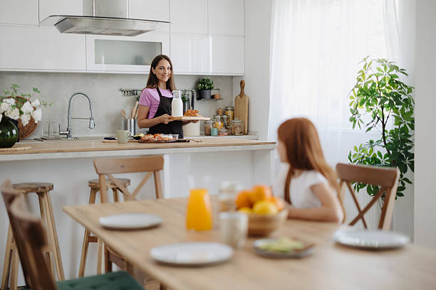 istock Mom and daughter preparing breakfast and setting the tab 2217714010