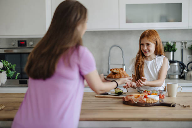 istock Mother with her daughter preparing breakfast at kitchen 2217714279