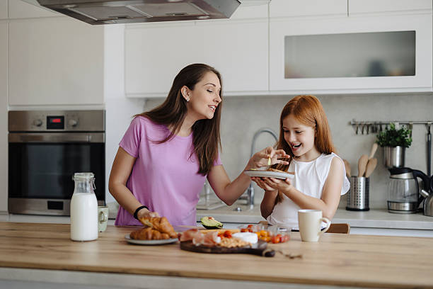 istock Mother with her daughter preparing breakfast at kitchen 2217714980