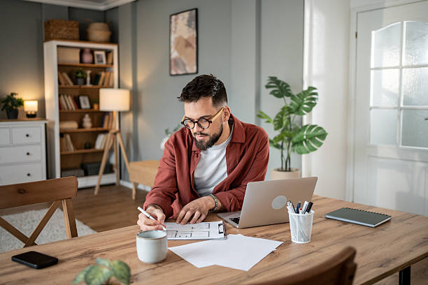 istock Focused architect reviewing blueprint in home office 2217715656