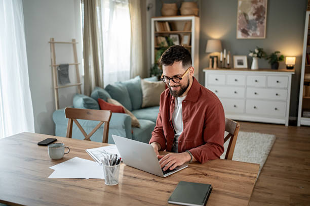 istock Architect working from home on laptop at the dining table 2217715667