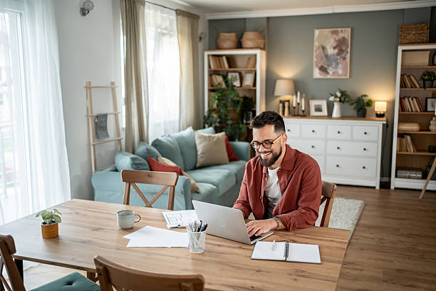 istock Architect working from home on laptop smiling at the screen 2217715715