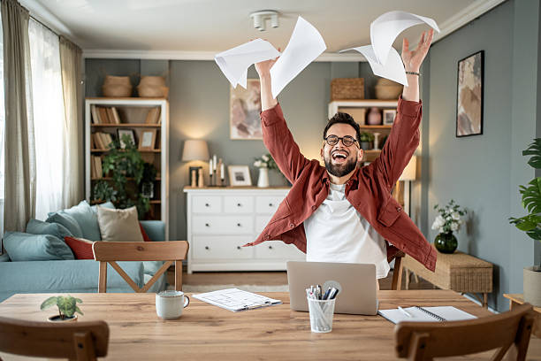istock Happy architect throwing papers in the air celebrating success working from home 2217715731