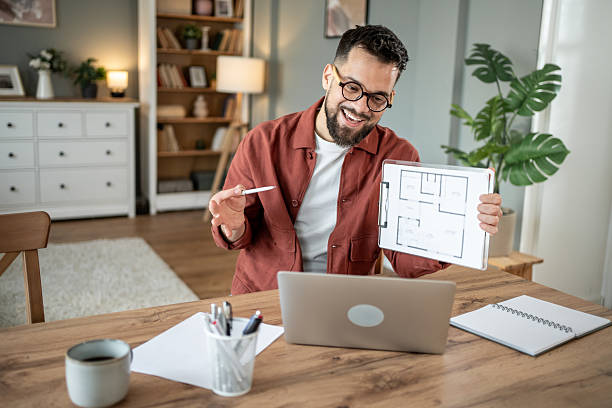 istock Architect showing blueprint during video call from home office 2217715770