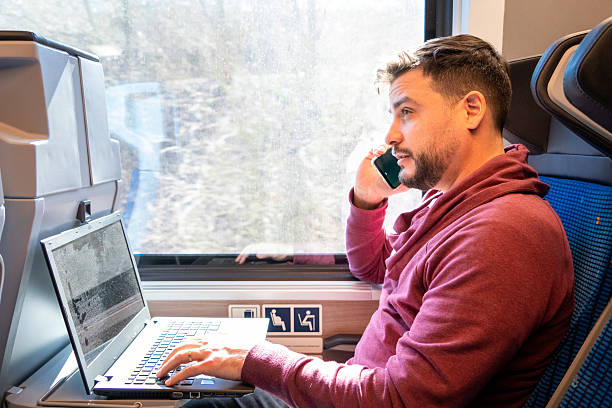 istock Young man traveling by train while working on his laptop. 2217715802