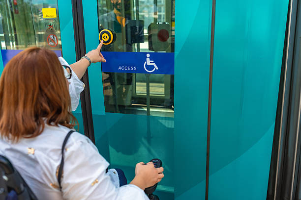 istock Woman in wheelchair entering public transport using accessible button 2217715903