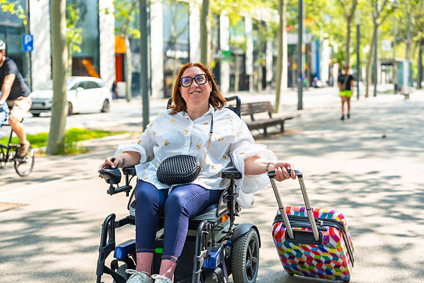 istock Happy tourist with disability pulling suitcase in electric wheelchair 2217715994