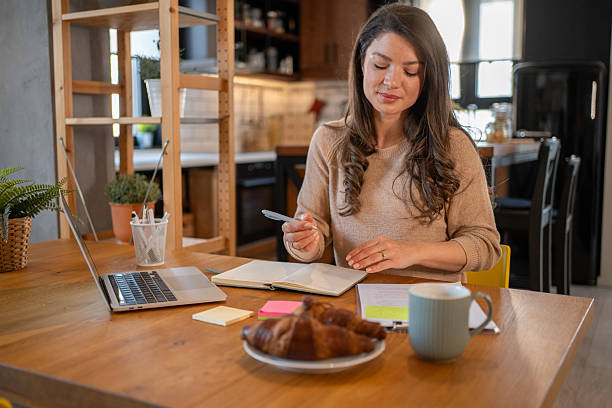 istock Focused freelancer working remotely from home office enjoying breakfast 2217716068