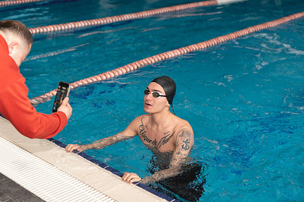 Swimming coach gives instructions to an athlete during training.