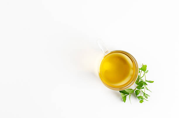 A transparent cup of mint tea and fresh mint leaves on white background. Top view with copy space.