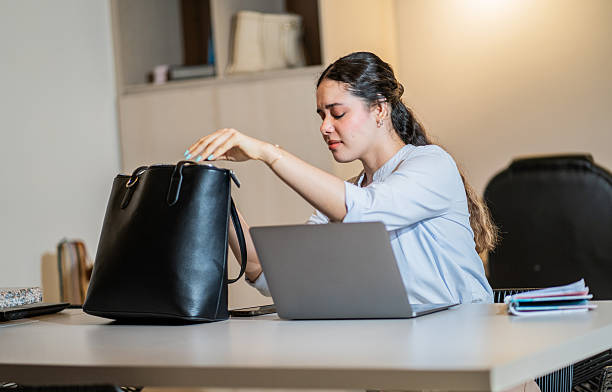 istock Young woman looking through her purse with frustrated expression in office. 2217725129