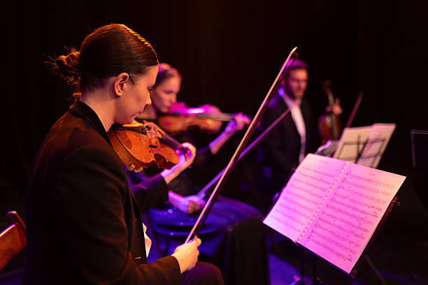 istock A focused violinist looks at the notes on the stand in front of her, during a string quartet concert 2217726382