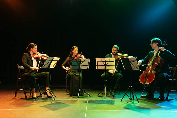istock The members of the string quartet, dressed in formal clothes, enjoy their performance in front of the audience on the theater stage 2217726426