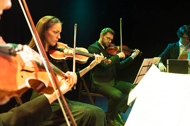 istock Violinists and a cellist play classical music on a theater stage 2217726452