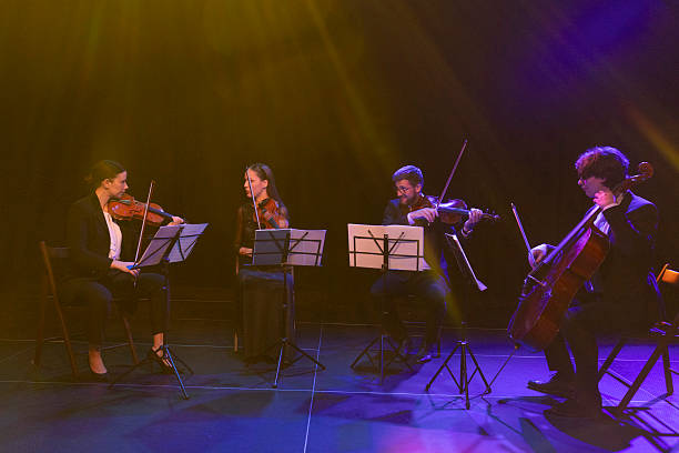 istock The string quartet dressed in formal clothes enjoy their performance in front of the audience on the theater stage 2217726460