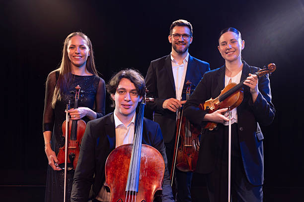 Portrait of a group of talented musicians looking directly into the camera while standing on stage