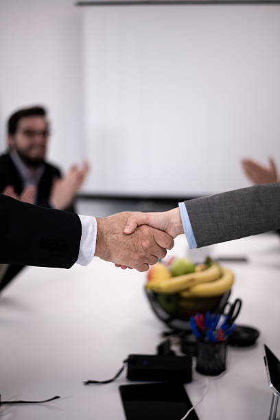 Two professionals shaking hands in a business meeting setting