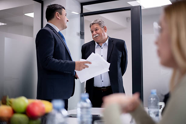 istock Two mature businessmen having a conversational discussion during a meeting in a modern office setting, with a focus on collaboration and professional interaction. 2217726717