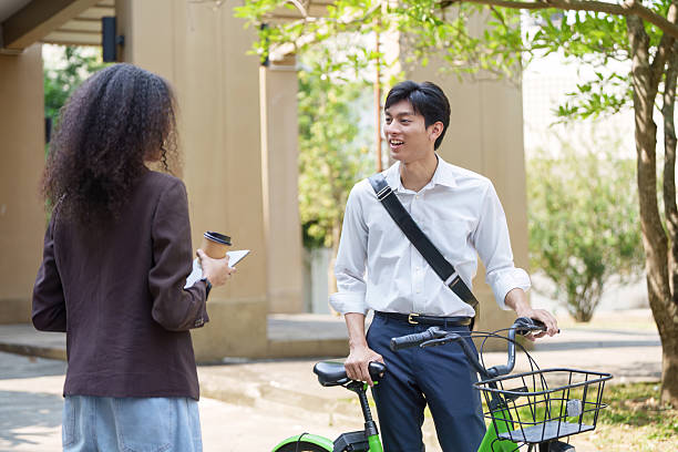 Sustainability and Urban Mobility. A cyclist discussing eco-friendly transport solutions with a friend.