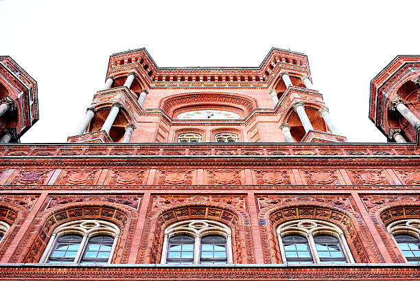 a central glimpse of the red town hall in Berlin seen from below