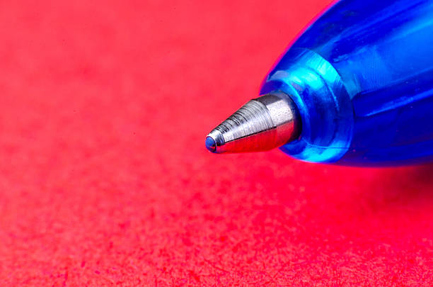 istock Blue ballpoint pen macro close-up on vibrant red background 2217747764