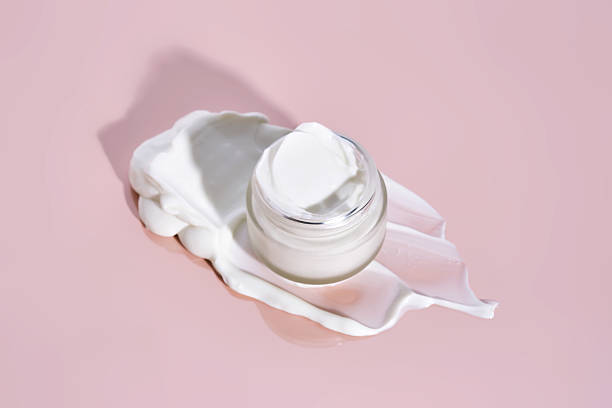 istock An open jar of cream with its texture on a pink background. 2217747896