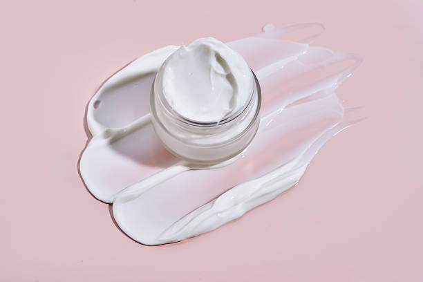 istock An open jar of cream with its texture on a pink background. 2217747920