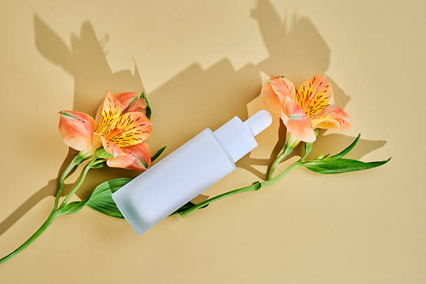istock Regenerating serum with lifting effect on beige background with lilies. 2217749305
